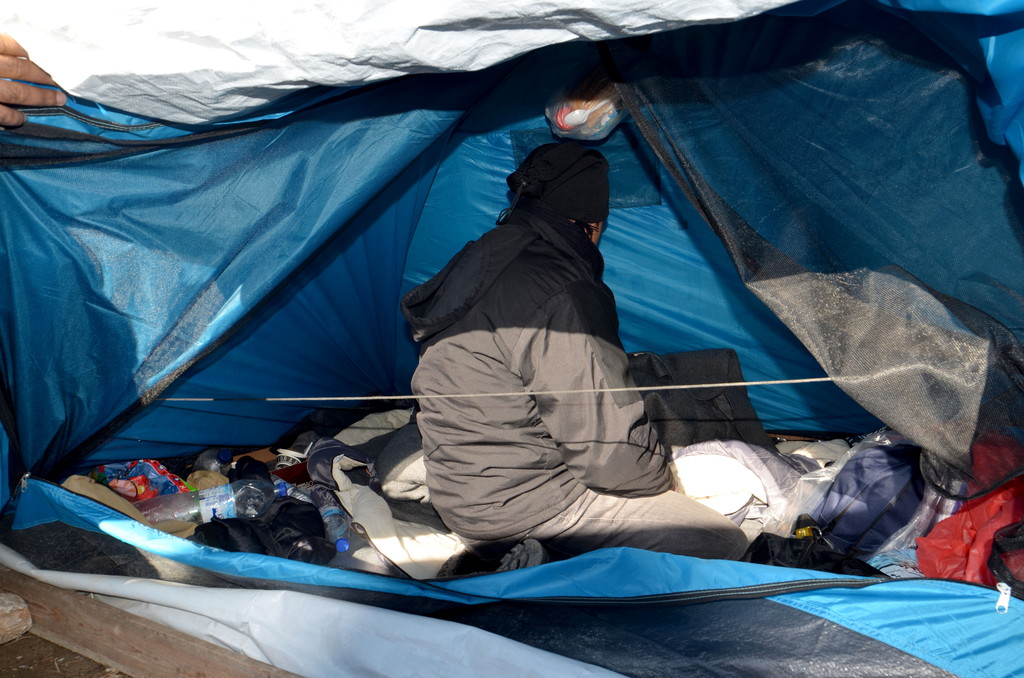 Refugee sat in a tent in Greece